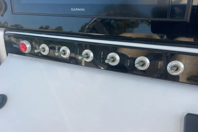 Slide: The Image of Control panel of a 2019 Sportsman Open 242 Center Console boat with toggle switches. - 36