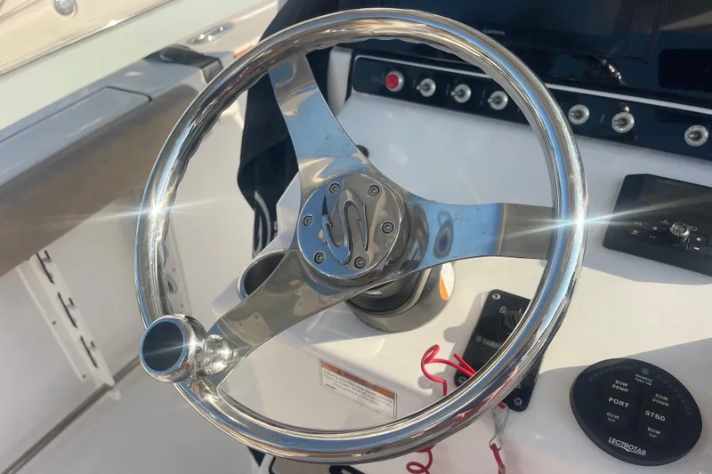 Slide: The Image of Steering wheel of a 2019 Sportsman Open 242 Center Console boat, with control panel. - 37