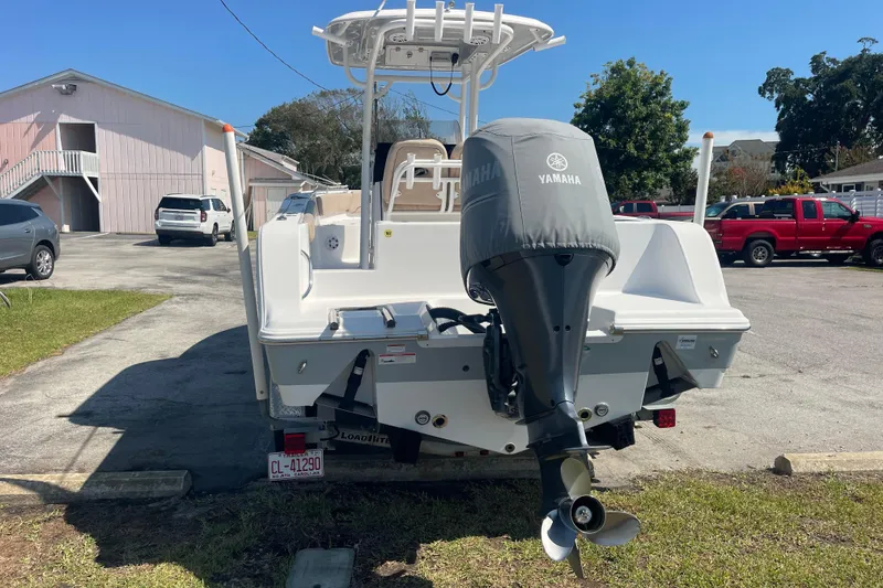 Slide: The Image of 2019 Sportsman Open 242 Center Console boat with Yamaha engine, parked outdoors. - 6