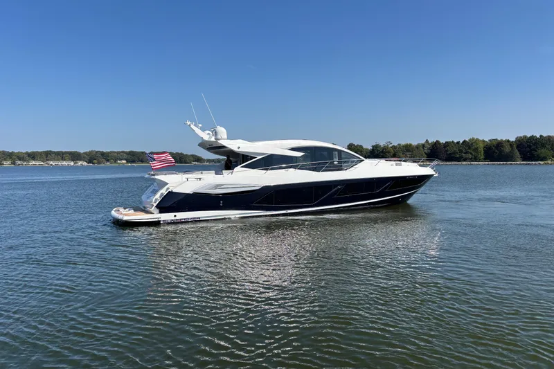Slide: The Image of 2018 Sunseeker Predator 74 yacht cruising on a calm lake under clear blue skies. - 12