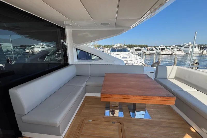 Slide: The Image of Luxurious Sunseeker Predator 74 yacht interior with elegant seating and wooden table, docked at marina. - 20