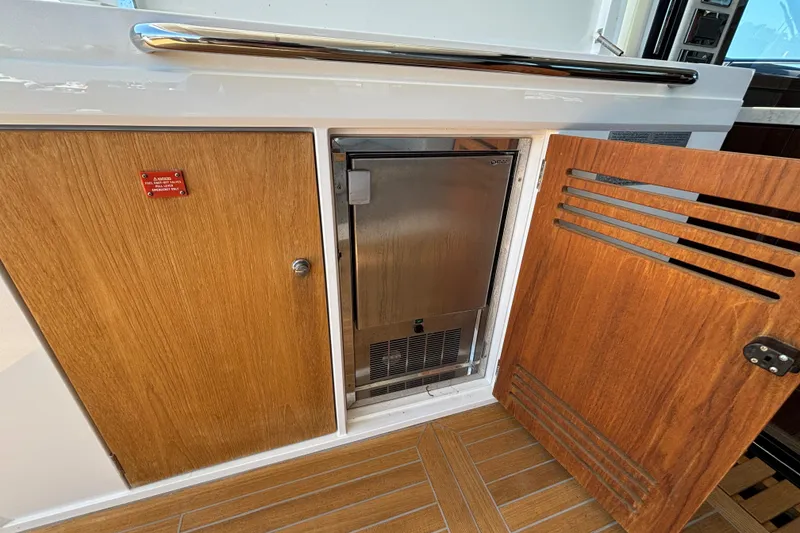Slide: The Image of Sunseeker Predator 74 yacht interior, featuring wooden cabinetry and a built-in stainless steel appliance. - 23