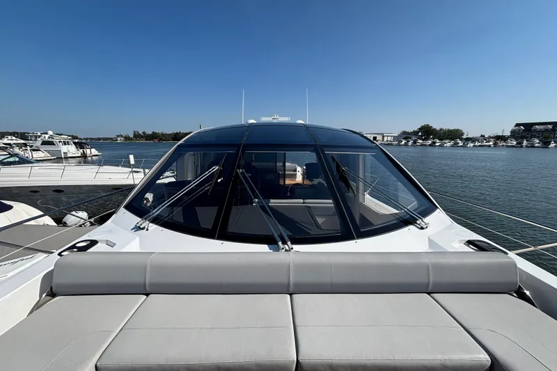 Slide: The Image of 2018 Sunseeker Predator 74 yacht with sleek design, docked in a marina under clear skies. - 28