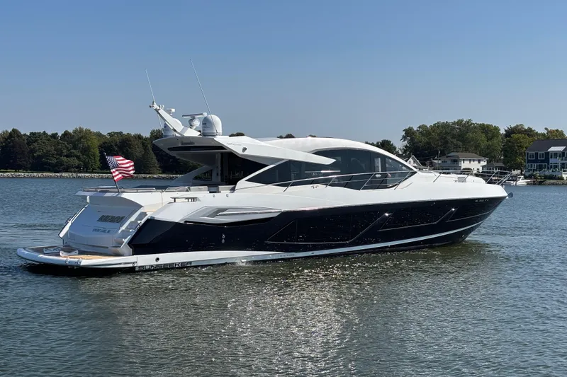 Slide: The Image of 2018 Sunseeker Predator 74 yacht cruising on a calm lake with American flag. - 3