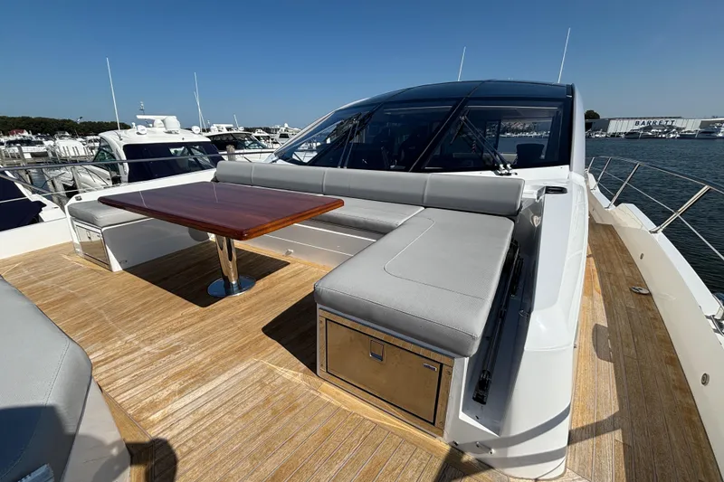 Slide: The Image of 2018 Sunseeker Predator 74 yacht deck with seating and wooden table. - 30