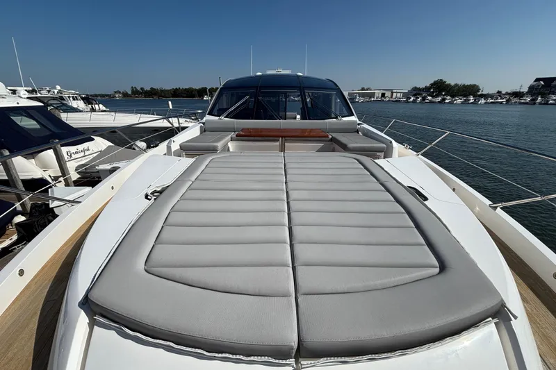 Slide: The Image of 2018 Sunseeker Predator 74 yacht with spacious sunbed, docked in a marina. - 32