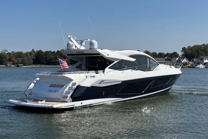 Slide: The Image of 2018 Sunseeker Predator 74 yacht cruising on a serene lake with clear skies. - 4