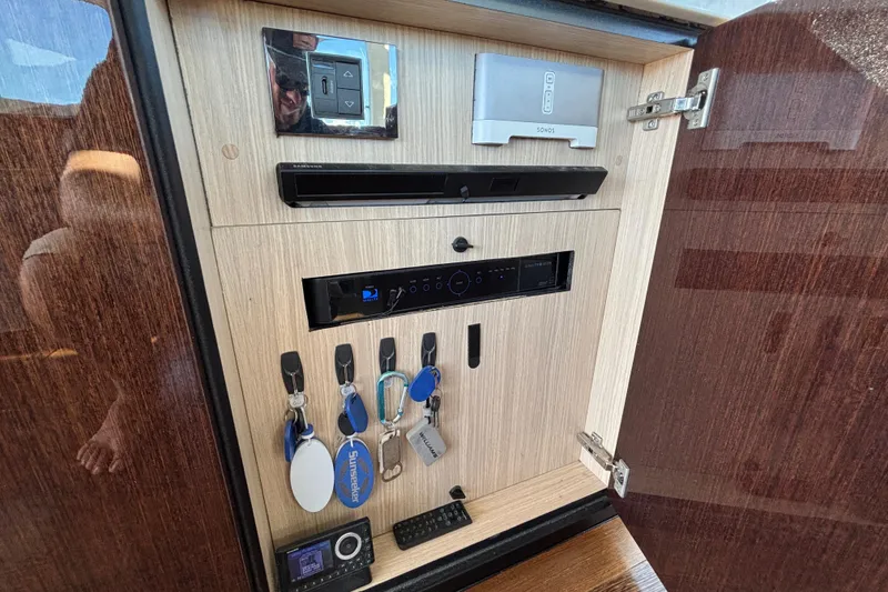 Slide: The Image of Interior cabinet of 2018 Sunseeker Predator 74 yacht with electronic controls and key storage. - 52