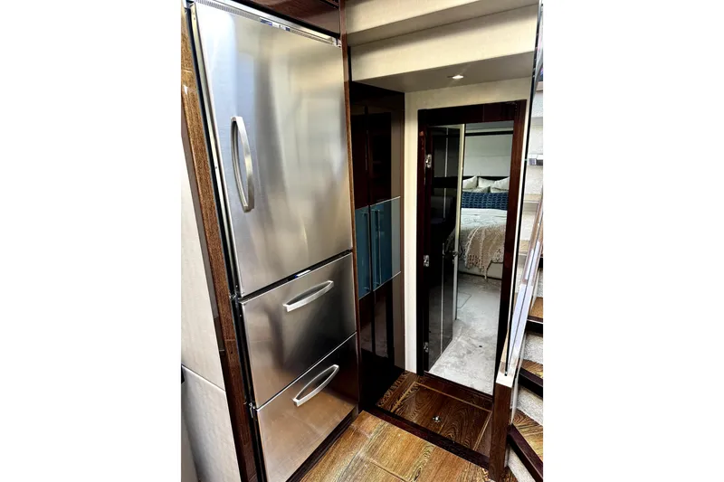 Slide: The Image of Luxurious interior of 2018 Sunseeker Predator 74 yacht, featuring stainless steel appliances and elegant bedroom. - 63