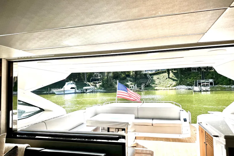 Slide: The Image of Interior view of 2018 Sunseeker Predator 74 yacht with American flag and scenic waterway. - 66