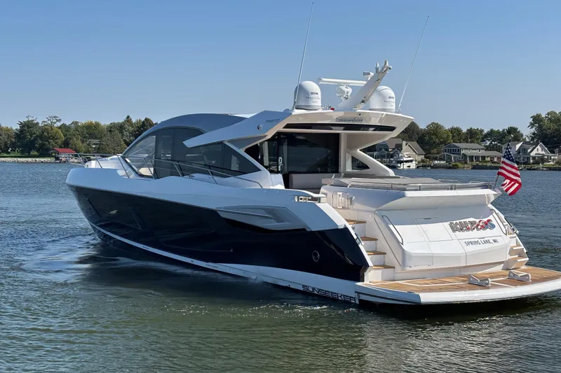 Slide: The Image of 2018 Sunseeker Predator 74 yacht cruising on a serene lake with American flag. - 7