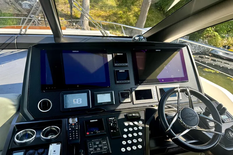 Slide: The Image of Control panel of a 2018 Sunseeker Predator 74 yacht with navigation screens and steering wheel. - 72