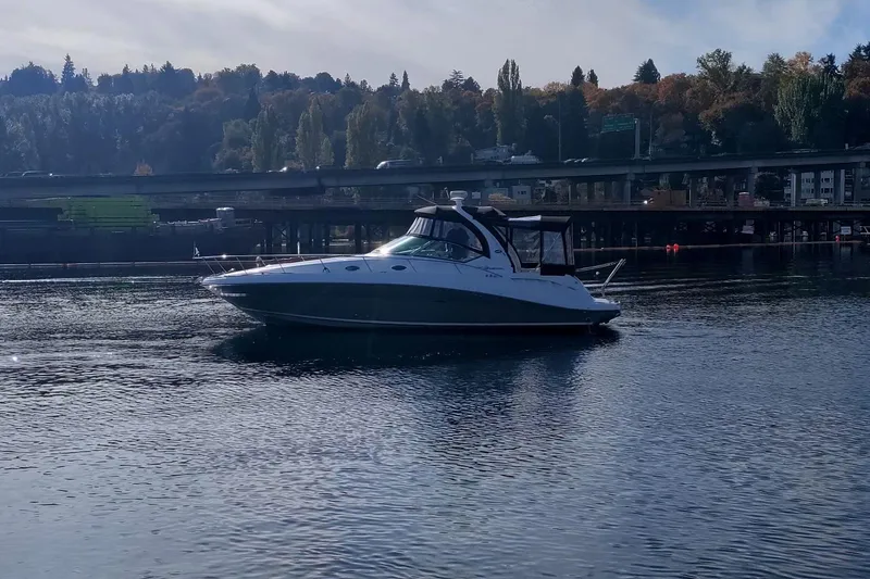 Slide: The Image of 2006 Sea Ray 340 Sundancer yacht cruising on a calm river with a scenic backdrop. - 20