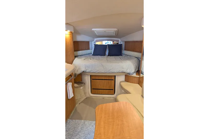 Slide: The Image of 2006 Sea Ray 340 Sundancer interior with TV, seating, and wooden table. - 6