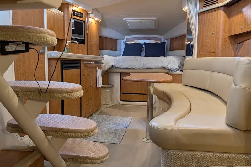 Slide: The Image of 2006 Sea Ray 340 Sundancer cabin interior with bed, wood cabinetry, and seating area. - 7