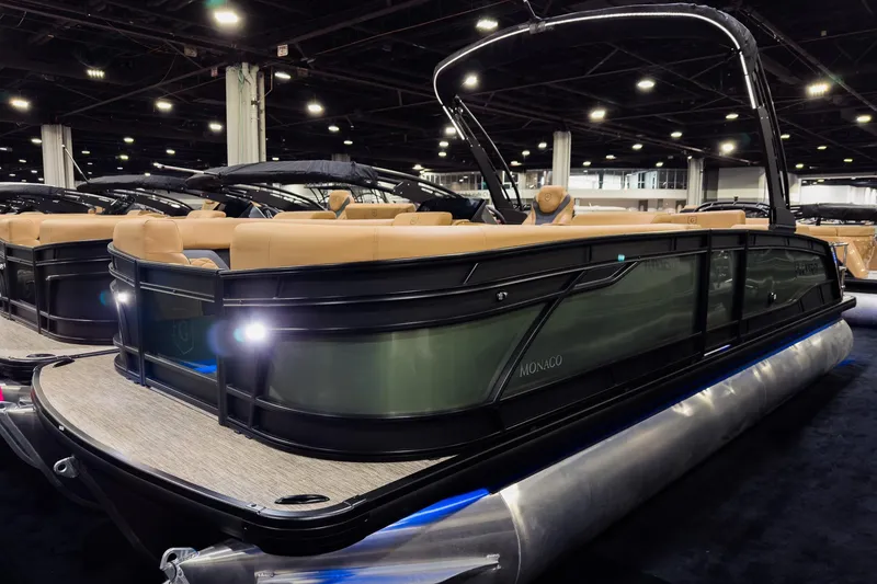 The Image of 2026 Godfrey Monaco 255 pontoon boat with luxurious seating at an indoor exhibition. - 0