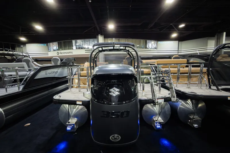 Slide: The Image of 2026 Godfrey Monaco 255 Single Flip Lounge pontoon boat displayed indoors. - 3