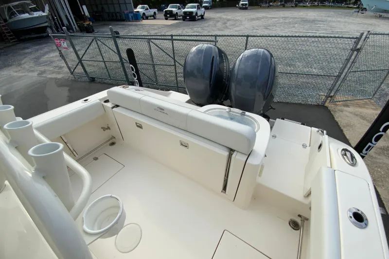 Slide: The Image of 2023 Cobia 262 Center Console boat with dual engines, docked in a marina. - 20