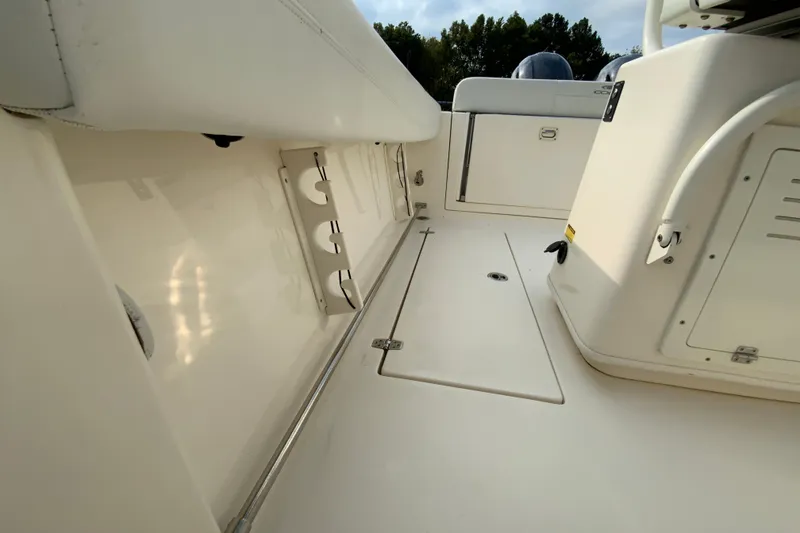 Slide: The Image of 2023 Cobia 262 Center Console boat interior, featuring storage compartments and rod holders. - 26