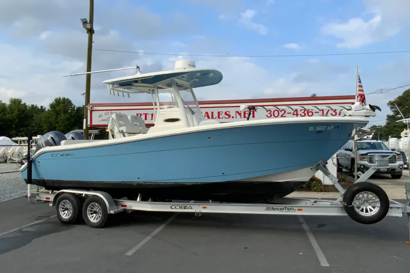 Slide: The Image of 2023 Cobia 262 Center Console boat on trailer, parked outdoors. - 3