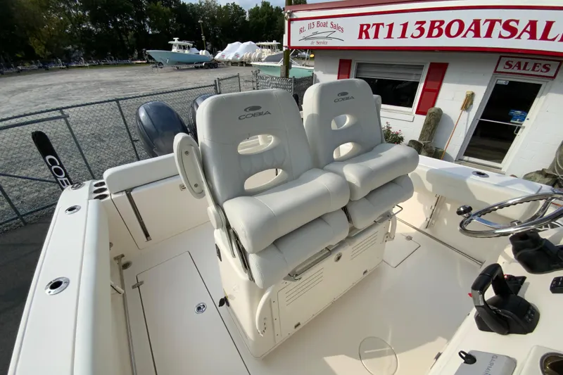 Slide: The Image of 2023 Cobia 262 Center Console boat with dual helm seats at a boat dealership. - 30