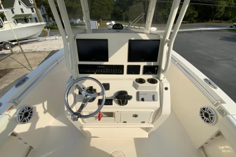 Slide: The Image of 2023 Cobia 262 Center Console boat dashboard with dual screens and steering wheel. - 36
