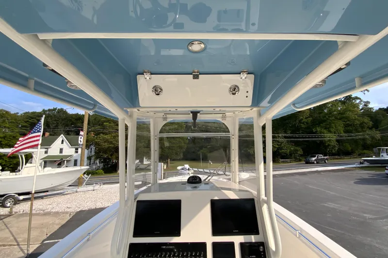 Slide: The Image of 2023 Cobia 262 Center Console boat interior with navigation screens and overhead storage. - 38