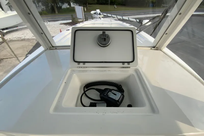 Slide: The Image of 2023 Cobia 262 Center Console storage compartment with radio handset. - 42