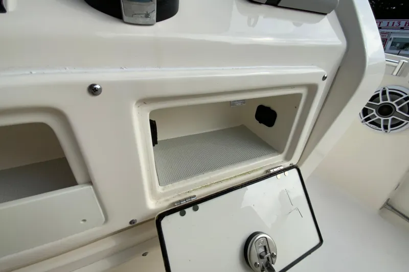 Slide: The Image of 2023 Cobia 262 Center Console storage compartment with open hatch and speaker detail. - 44