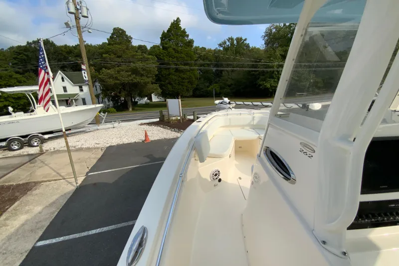 Slide: The Image of 2023 Cobia 262 Center Console boat displayed outdoors with American flag nearby. - 47