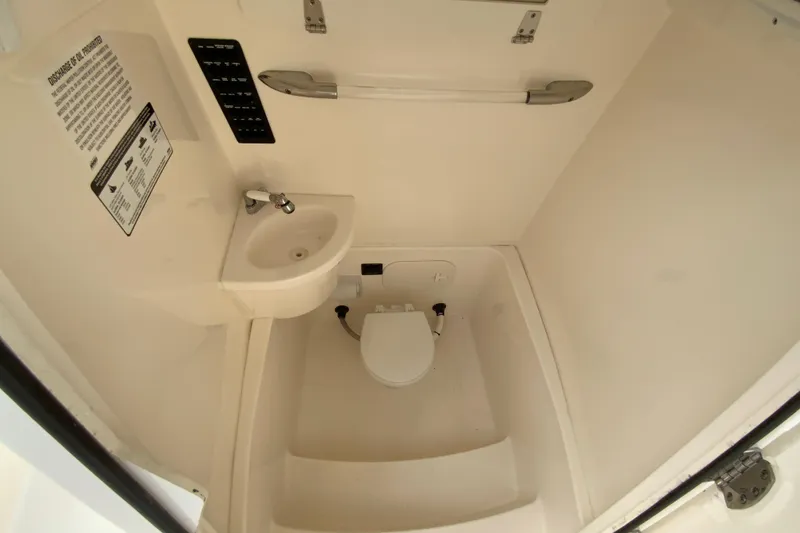 Slide: The Image of 2023 Cobia 262 Center Console boat interior with compact sink and toilet. - 52