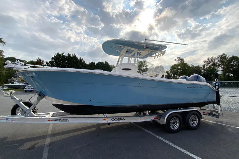 Slide: The Image of 2023 Cobia 262 Center Console boat on trailer under cloudy sky. - 9