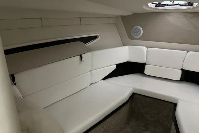 Slide: The Image of Interior of 2026 Regal 26 XO boat with white cushioned seating and circular window. - 11