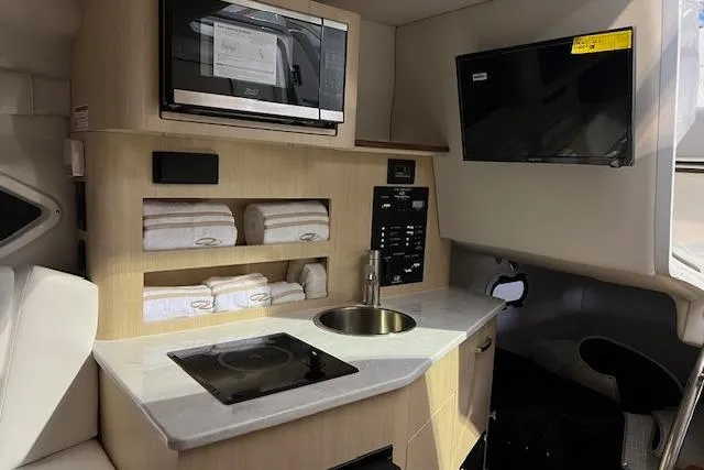 Slide: The Image of Modern kitchen in 2026 Regal 26 XO boat with microwave, sink, and stove. - 12