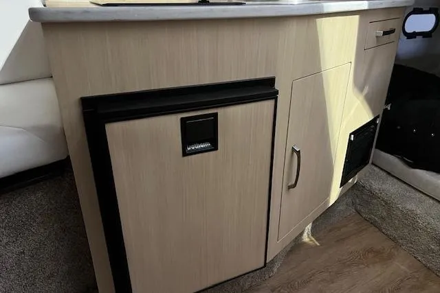 Slide: The Image of Interior of 2026 Regal 26 XO boat with compact kitchenette and storage. - 13