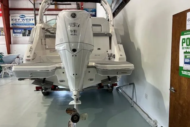Slide: The Image of 2026 Regal 26 XO boat in showroom, rear view with outboard motor. - 2
