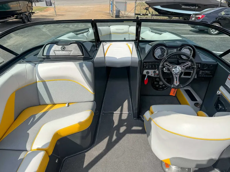 Slide: The Image of 2016 Moomba Craz boat interior with gray and yellow seating, steering wheel, and dashboard controls. - 11