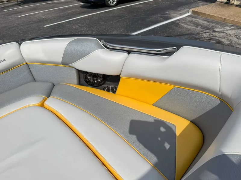 Slide: The Image of 2016 Moomba Craz boat interior with gray and yellow seating, featuring a speaker. - 14