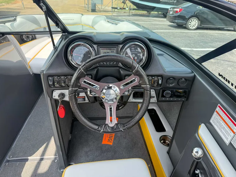 Slide: The Image of 2016 Moomba Craz boat dashboard with steering wheel and gauges. - 16