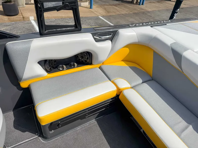 Slide: The Image of 2016 Moomba Craz boat interior with gray and yellow seating, cup holders, and speakers. - 18