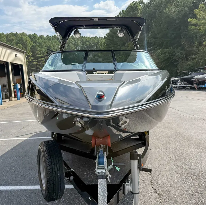 Slide: The Image of 2016 Moomba Craz boat on trailer, parked outdoors near trees and a building. - 4