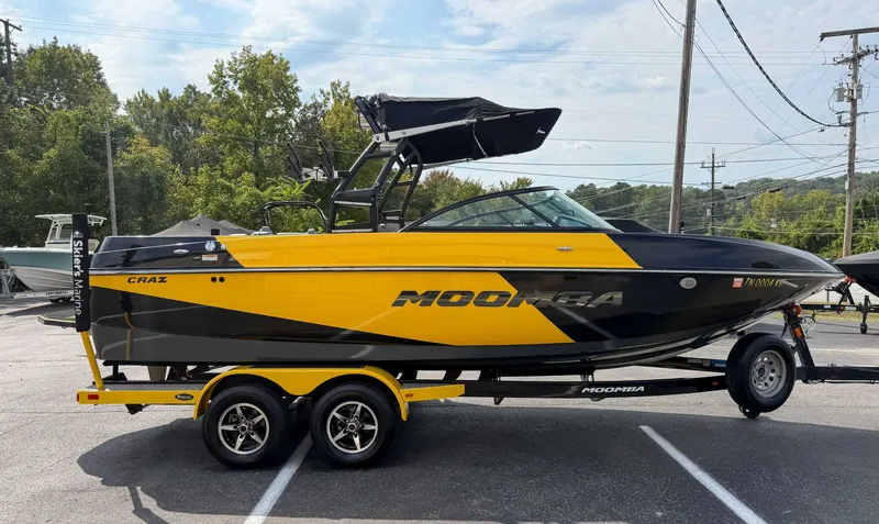 Slide: The Image of 2016 Moomba Craz boat in black and yellow on a trailer, parked outdoors. - 6