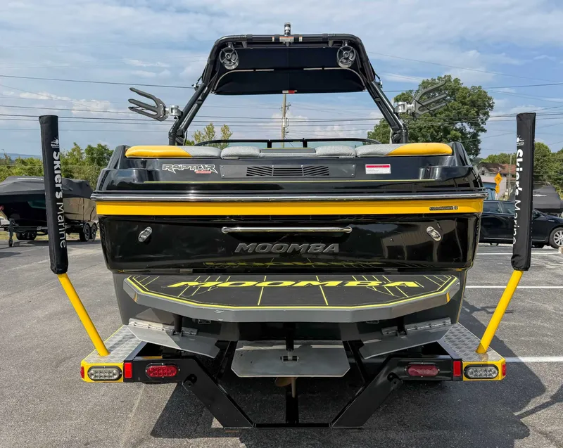 Slide: The Image of 2016 Moomba Craz boat rear view with yellow accents, parked outdoors. - 9