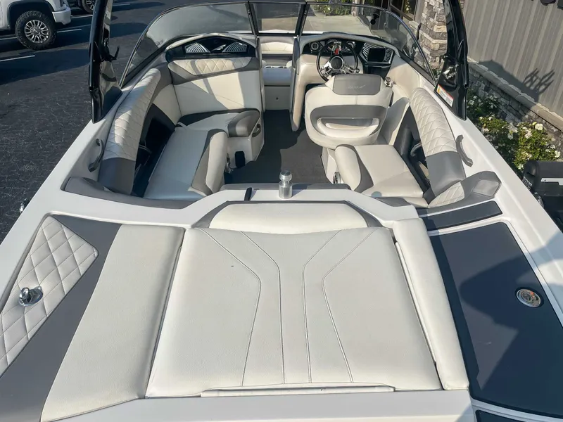 Slide: The Image of 2014 Tigé RZR boat interior with white and gray seating, steering wheel, and dashboard. - 10