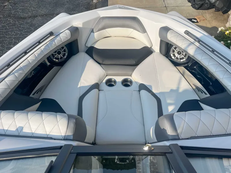 Slide: The Image of 2014 Tigé RZR boat interior with white and gray seating, cup holders, and speakers. - 12