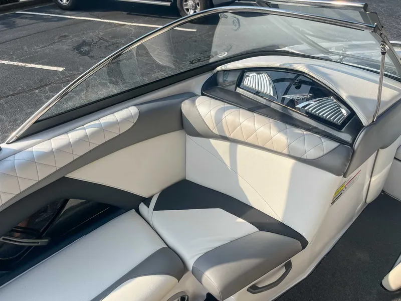 Slide: The Image of 2014 Tigé RZR boat interior with white and gray seating, diamond stitching, and dashboard. - 14