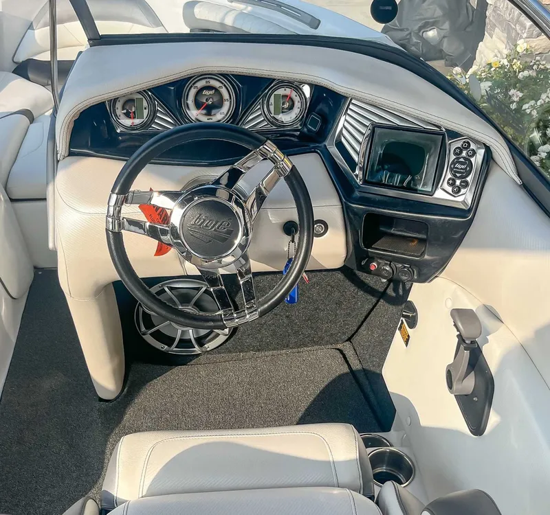 Slide: The Image of 2014 Tigé RZR boat dashboard with steering wheel and gauges. - 16
