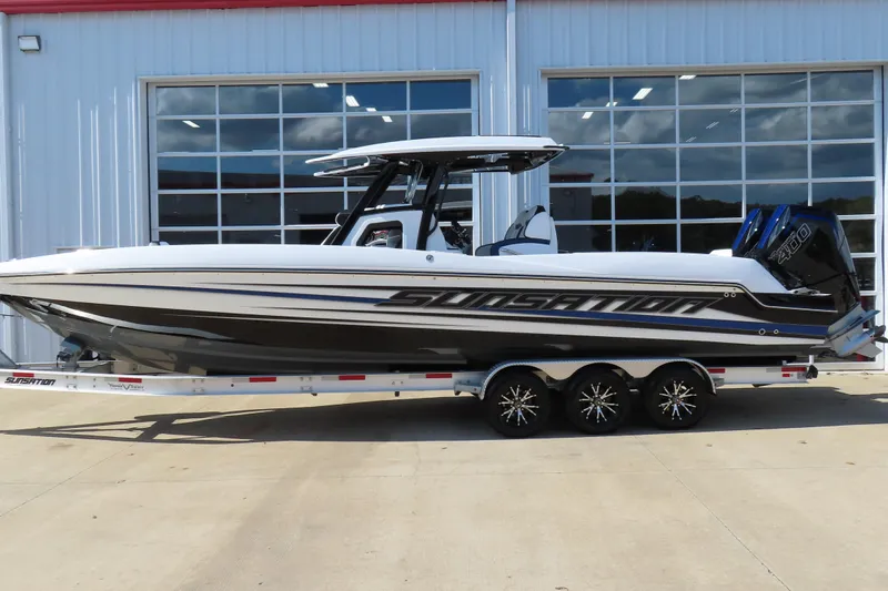 The Image of 2026 Sunsation 32CCX boat on trailer, sleek design, parked outside a building. - 1