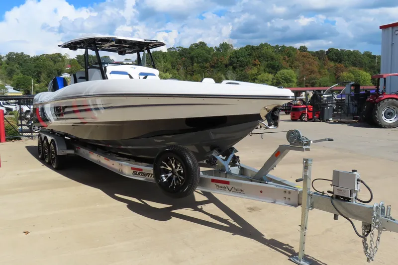 Slide: The Image of 2026 Sunsation 32CCX boat on trailer, parked outdoors under a partly cloudy sky. - 4