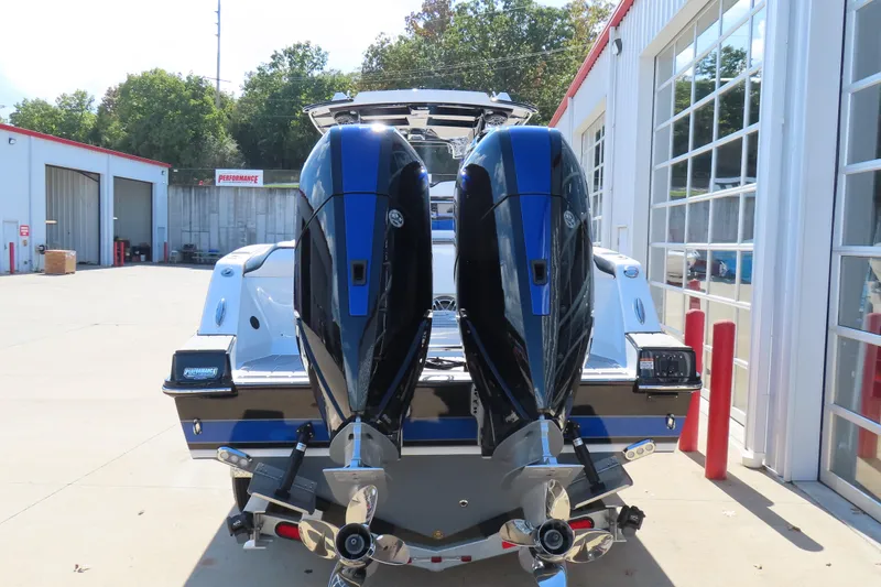 Slide: The Image of 2026 Sunsation 32CCX boat with dual outboard engines, parked outside a garage. - 6